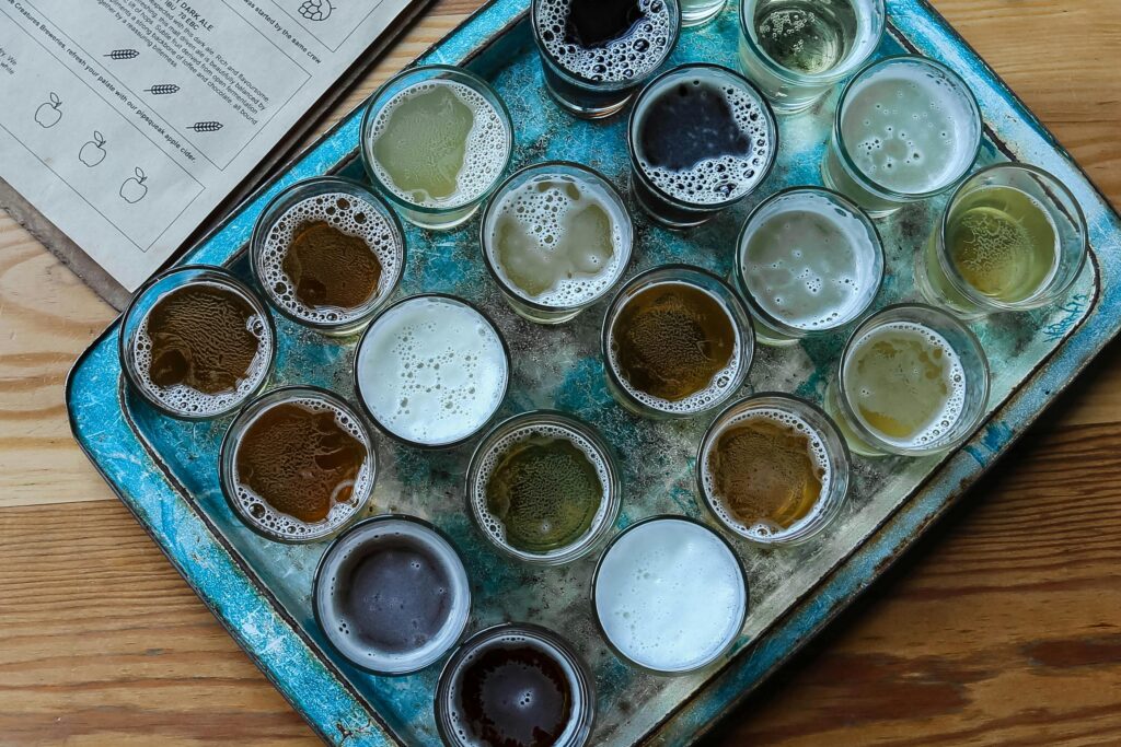 Aerial view of assorted beer glasses on a rustic tray, perfect for brewery tasting sessions.